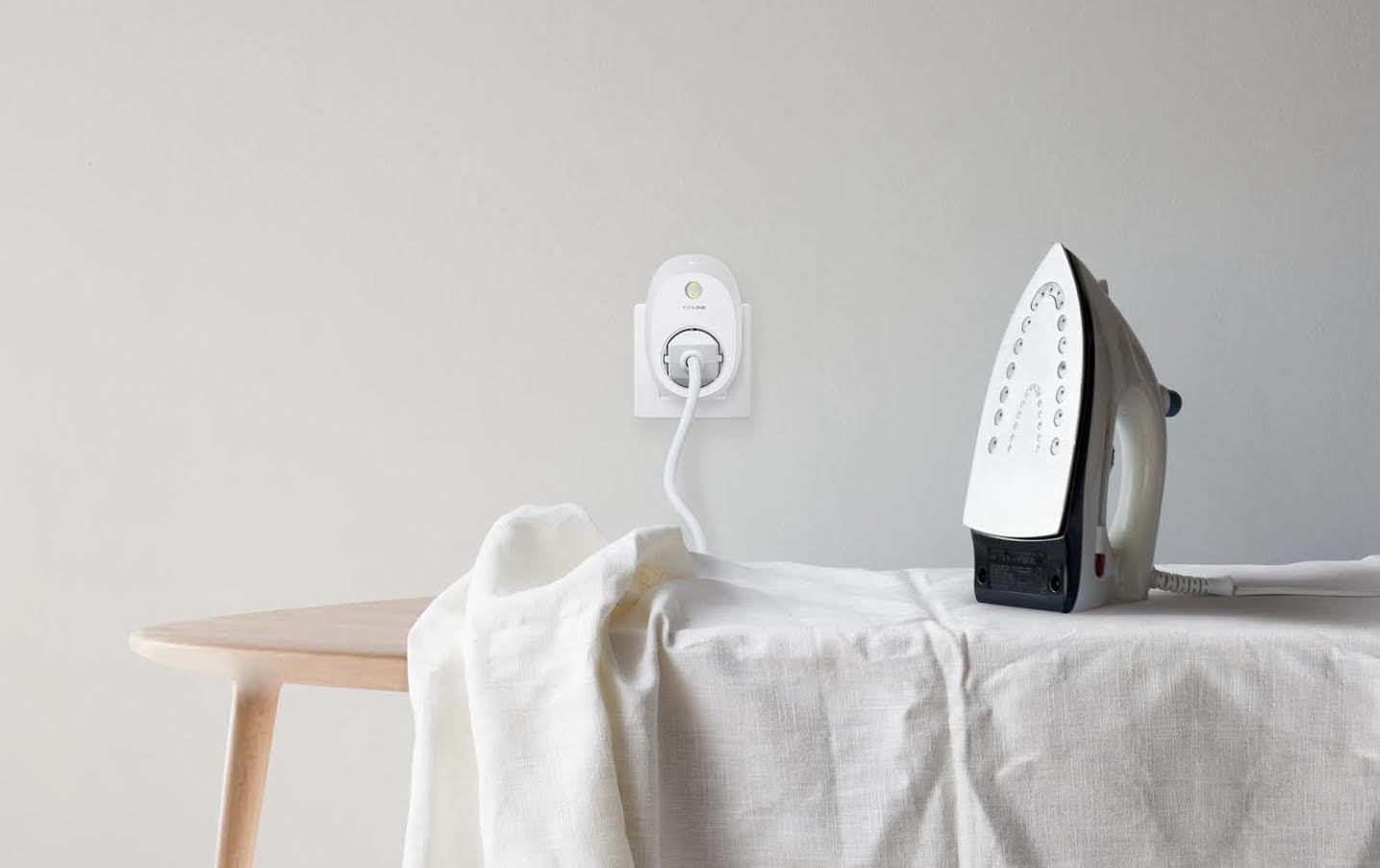 White tablecloth and iron on ironing board